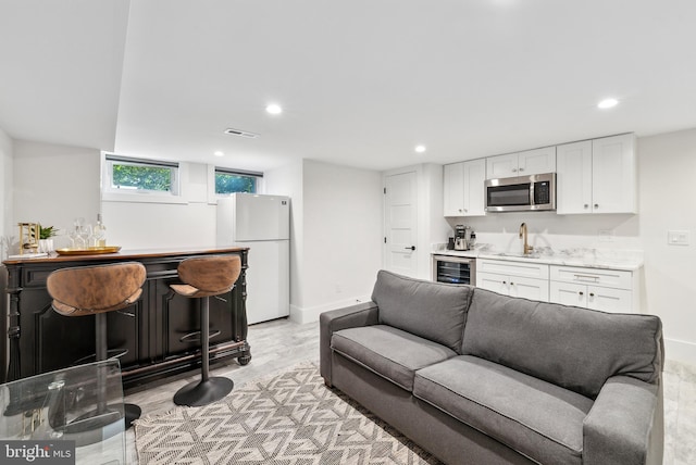 living room with a dry bar, visible vents, wine cooler, light wood-type flooring, and recessed lighting