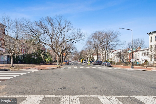 view of street with street lighting, a residential view, curbs, and sidewalks