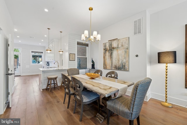 dining room featuring a chandelier, wood finished floors, visible vents, and recessed lighting