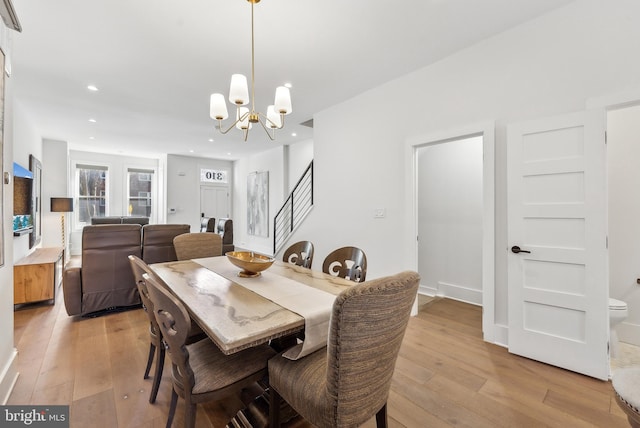 dining room featuring recessed lighting, stairway, light wood-type flooring, and an inviting chandelier