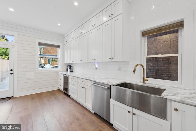 kitchen with light stone counters, wine cooler, white cabinetry, and dishwasher