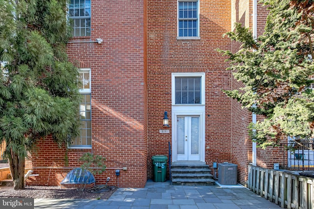 entrance to property with brick siding and central AC unit