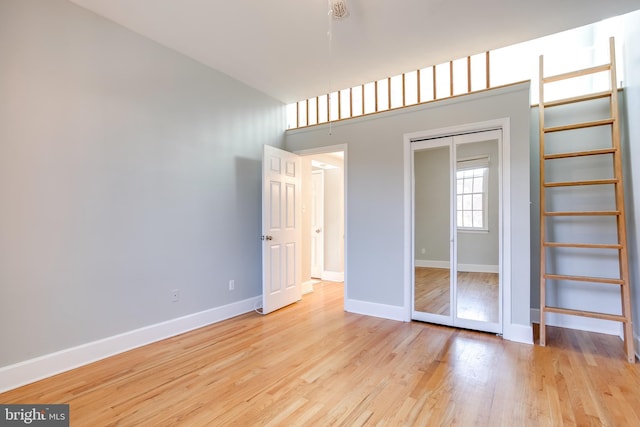 interior space featuring light wood finished floors, a closet, and baseboards