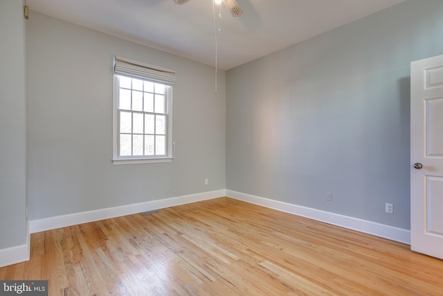 unfurnished room featuring ceiling fan, light wood-type flooring, visible vents, and baseboards