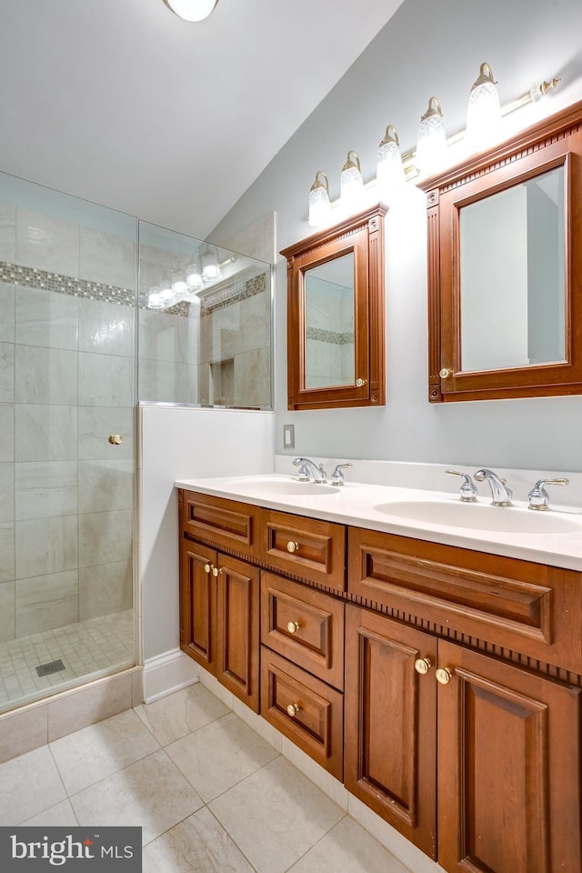 bathroom with double vanity, vaulted ceiling, a sink, and tiled shower