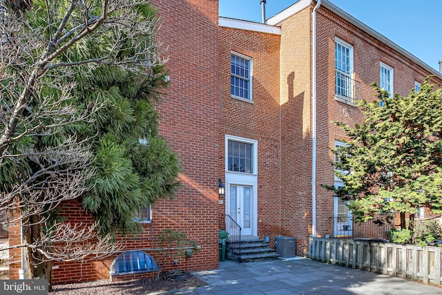 view of building exterior with entry steps and cooling unit