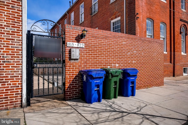 view of home's exterior featuring brick siding, fence, and a gate