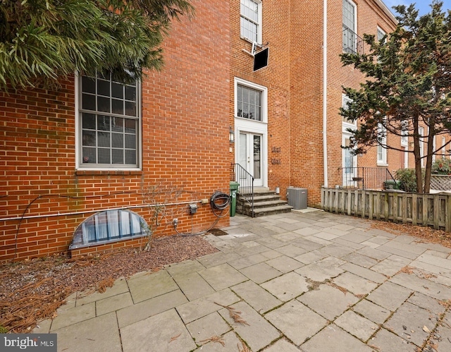 property entrance featuring brick siding and a patio