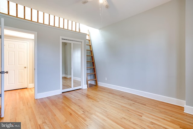 unfurnished bedroom with baseboards, a closet, and light wood-style floors