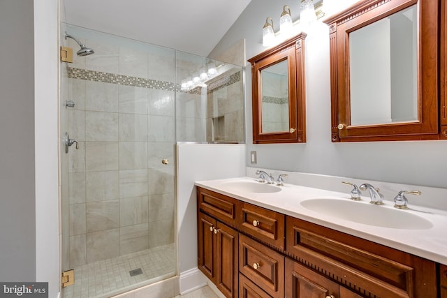 full bathroom featuring double vanity, a stall shower, and a sink