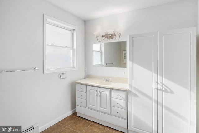 bathroom with baseboard heating, tile patterned flooring, vanity, and baseboards