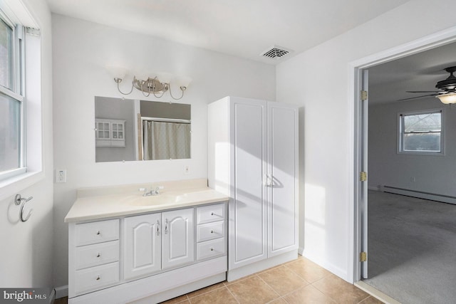 bathroom featuring visible vents, a baseboard heating unit, a ceiling fan, vanity, and tile patterned floors