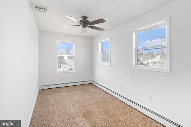 unfurnished room with a healthy amount of sunlight, light carpet, visible vents, and baseboard heating