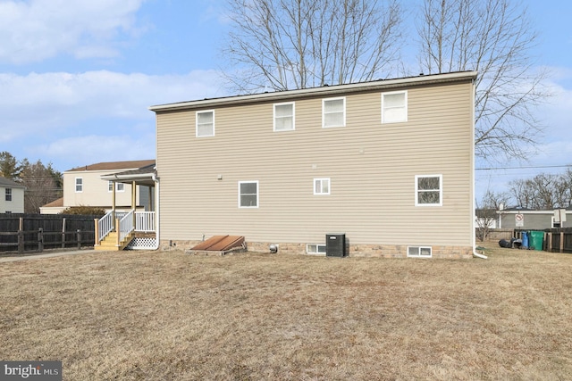 back of house with fence and a lawn