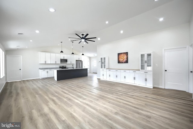 unfurnished living room featuring recessed lighting, ceiling fan, light wood-style flooring, and a sink