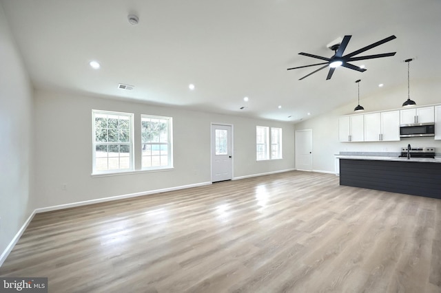 unfurnished living room with lofted ceiling, baseboards, visible vents, and light wood-style floors