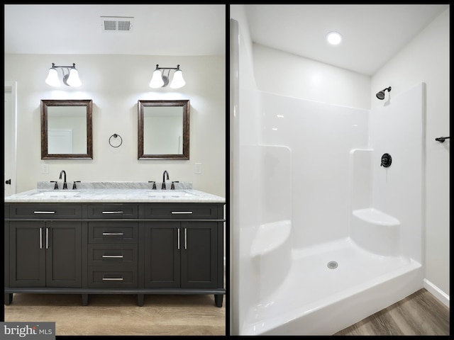 bathroom featuring double vanity, walk in shower, a sink, and visible vents