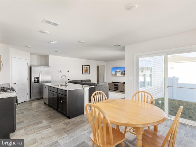 dining space featuring light wood-style floors and visible vents