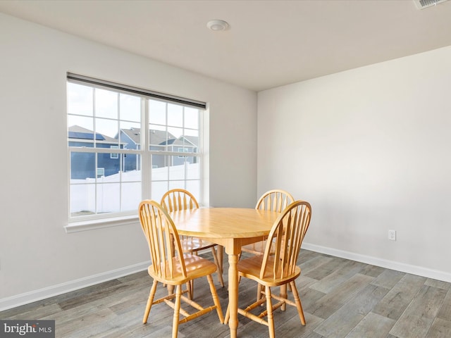 dining space featuring baseboards and wood finished floors