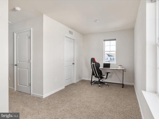 office featuring baseboards, visible vents, and light colored carpet