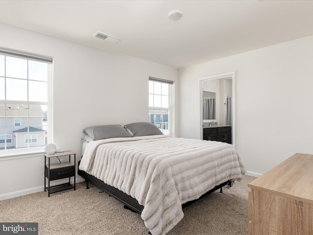 bedroom with visible vents, baseboards, connected bathroom, and light colored carpet