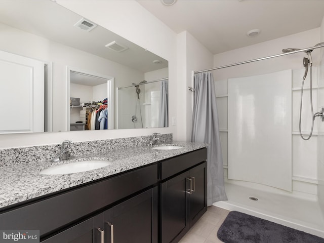 full bathroom featuring visible vents, a sink, a spacious closet, and a shower stall