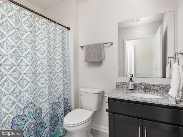 bathroom featuring toilet, vanity, and visible vents