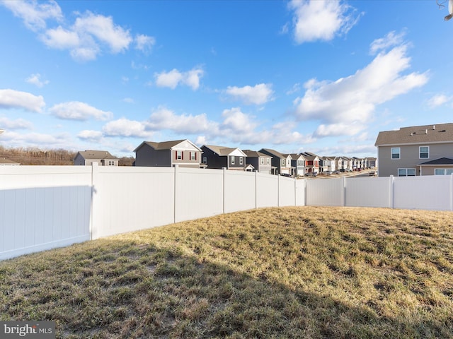 view of yard with a fenced backyard and a residential view