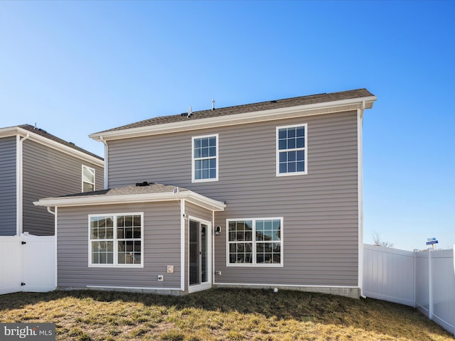 back of house featuring a yard and a fenced backyard