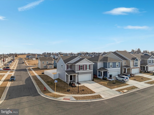 view of front of house with concrete driveway, an attached garage, and a residential view