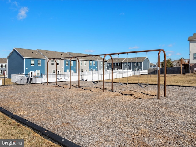 view of front of home featuring a residential view, fence, and playground community