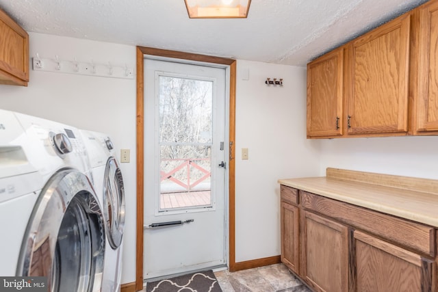 laundry area featuring a healthy amount of sunlight, cabinet space, washing machine and dryer, and a textured ceiling