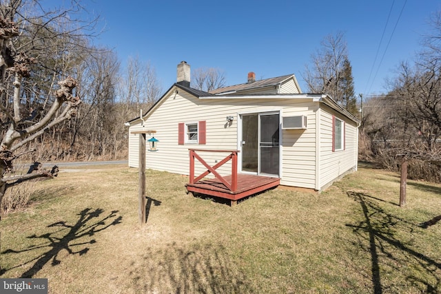 back of house featuring a chimney and a yard