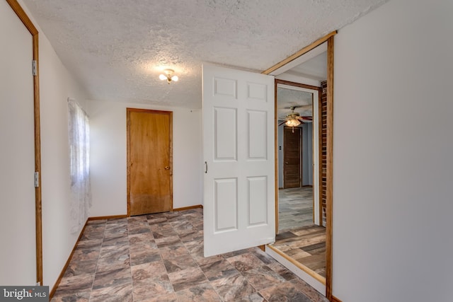 spare room with baseboards and a textured ceiling