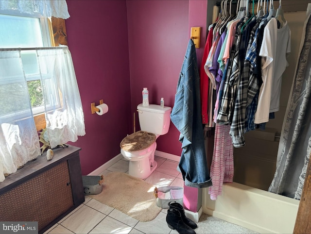 bathroom with shower / bath combination with curtain, baseboards, toilet, and tile patterned floors