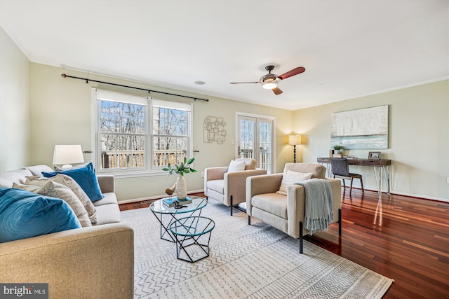 living room featuring crown molding, baseboards, and hardwood / wood-style floors