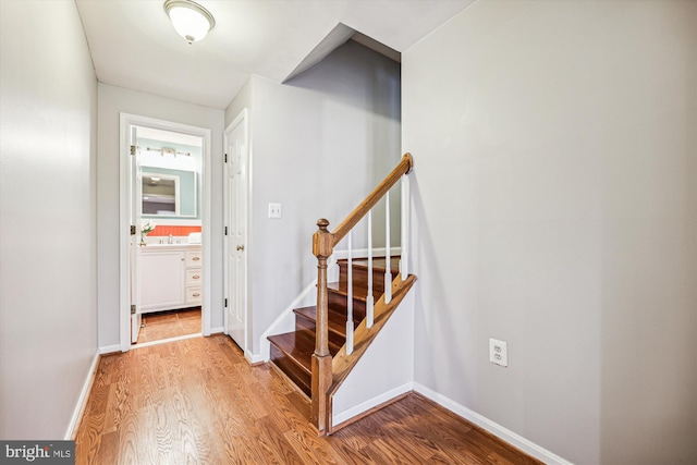 stairway with baseboards and wood finished floors