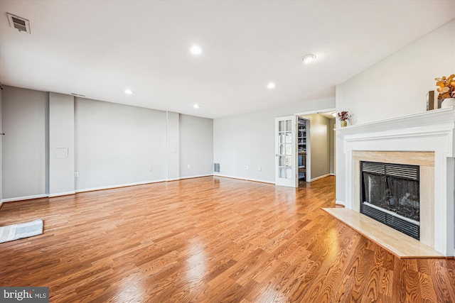 unfurnished living room featuring light wood finished floors, baseboards, visible vents, a fireplace, and recessed lighting