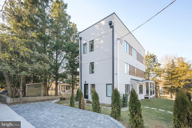 view of side of property with a lawn and stucco siding