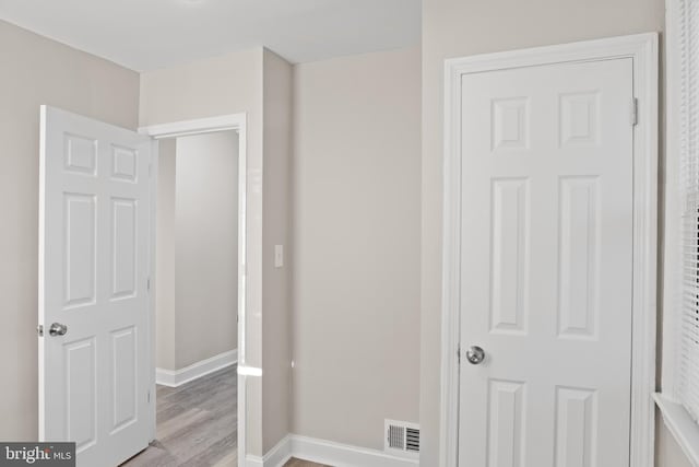 bedroom featuring light wood-style floors, visible vents, and baseboards