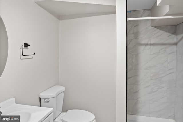 full bath featuring vanity, a marble finish shower, and toilet