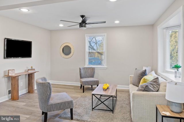 living area with light wood-style floors, baseboards, and recessed lighting