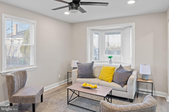 living room featuring light wood-style floors, baseboards, and a wealth of natural light