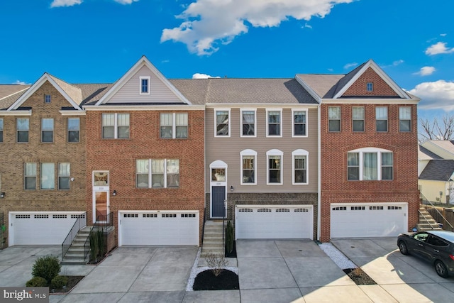 multi unit property featuring a garage, brick siding, and driveway