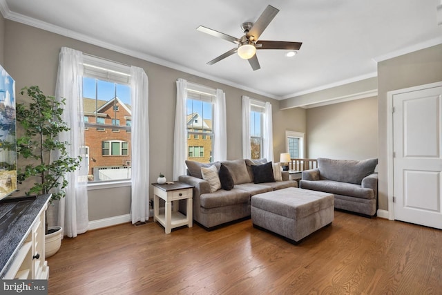 living area featuring crown molding, baseboards, and wood finished floors