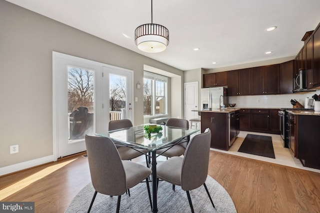 dining space featuring light wood finished floors, baseboards, and recessed lighting