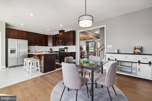 dining room featuring light wood-type flooring, stairs, and recessed lighting