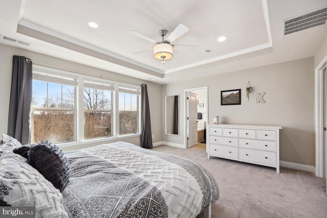 bedroom featuring light carpet, a tray ceiling, visible vents, and baseboards