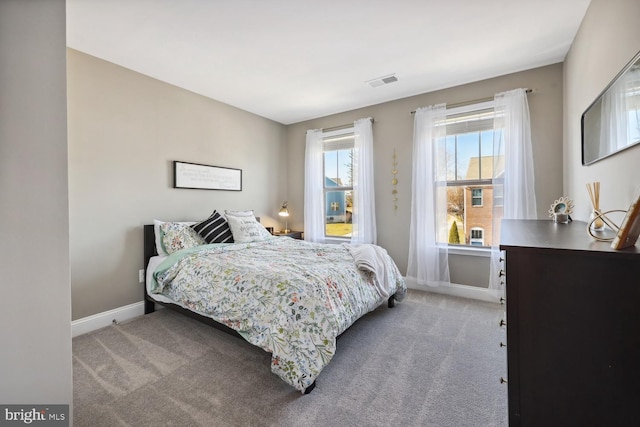 bedroom featuring baseboards, visible vents, and light colored carpet