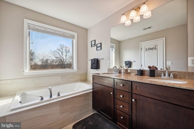 full bathroom with plenty of natural light, visible vents, and a sink